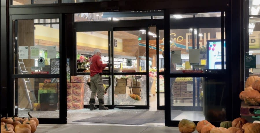 A worker boards up windows following a shooting at the Whole Foods store on Oct. 4, 2021. (KSN Reporter Hunter Funk)