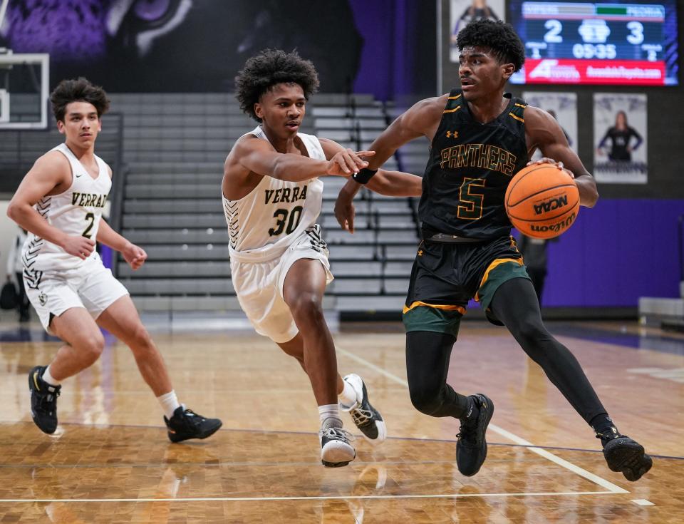 Peoria's Calvin Windley (5), dribbles to the basket while guarded by Verrado's Sam Chabala (30), and Verrado's Lorenzo Lizarraga (2), during a Thanksgiving boys basketball tournament at Millennium High School on Wednesday, Nov. 23, 2022, in Goodyear. The game finished 81-34 to Peoria.