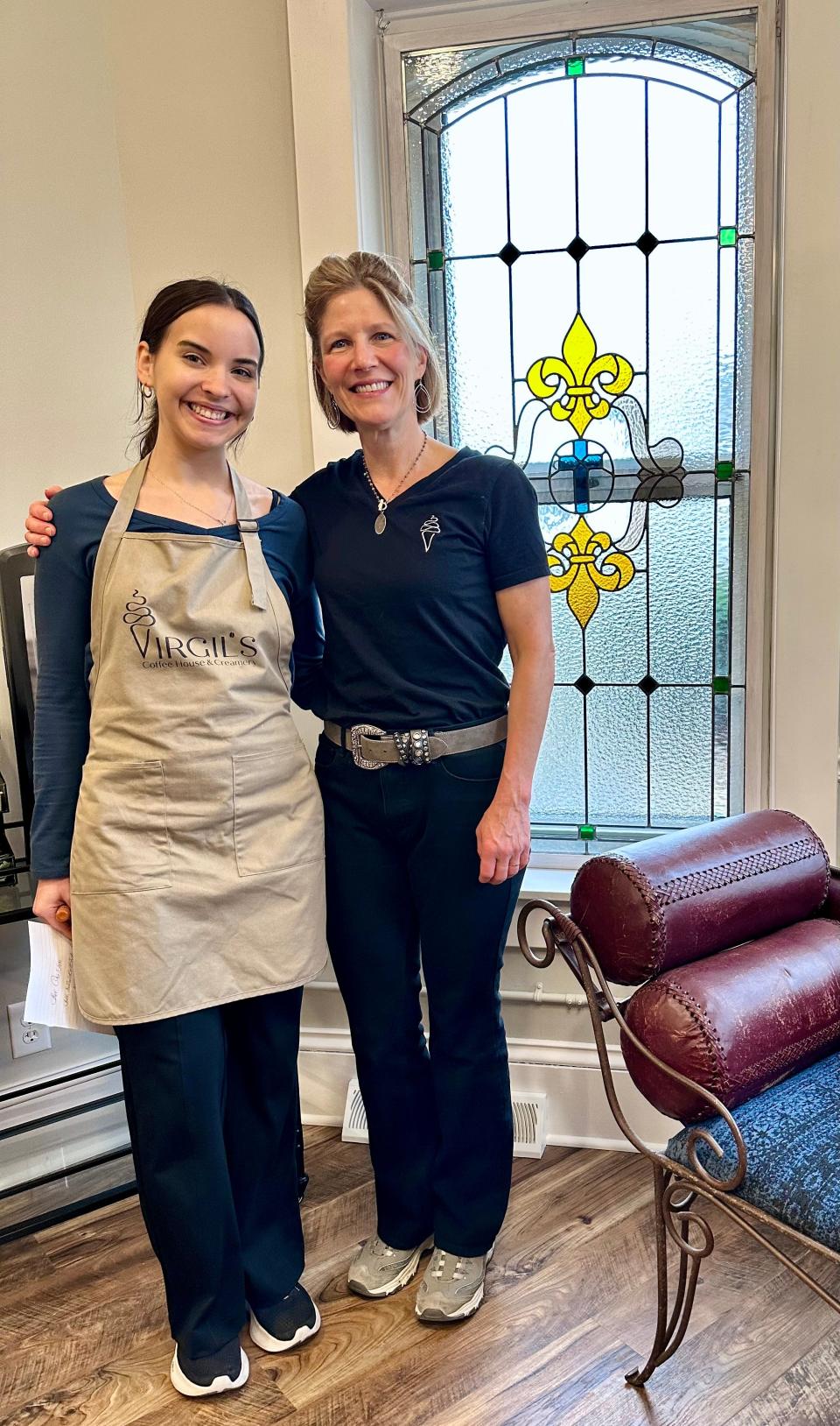 Jordan Parisi, left, operations manager at Virgil's, and Chery Rich, co-owner, stand in front of one of the stained-glass windows inside the historic Louisville home that now houses a coffee and ice cream shop.