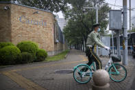 A Chinese paramilitary policeman rides a bicycle past the Canadian Embassy in Beijing, Saturday, Sept. 25, 2021. Two Canadians detained in China on spying charges were released from prison and flown out of the country on Friday, Prime Minister Justin Trudeau announced Friday, hours after a top executive of Chinese communications giant Huawei Technologies resolved criminal charges against her in a deal with the U.S. Justice Department. (AP Photo/Mark Schiefelbein)