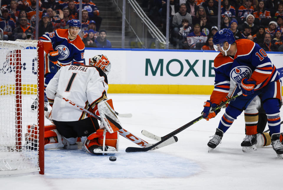 Anaheim Ducks goalie Lukas Dostal (1) looks on as Edmonton Oilers forward Dylan Holloway, back left, and forward Derek Ryan (10) try to score during second-period NHL hockey game action in Edmonton, Alberta, Saturday, Dec. 17, 2022. (Jeff McIntosh/The Canadian Press via AP)