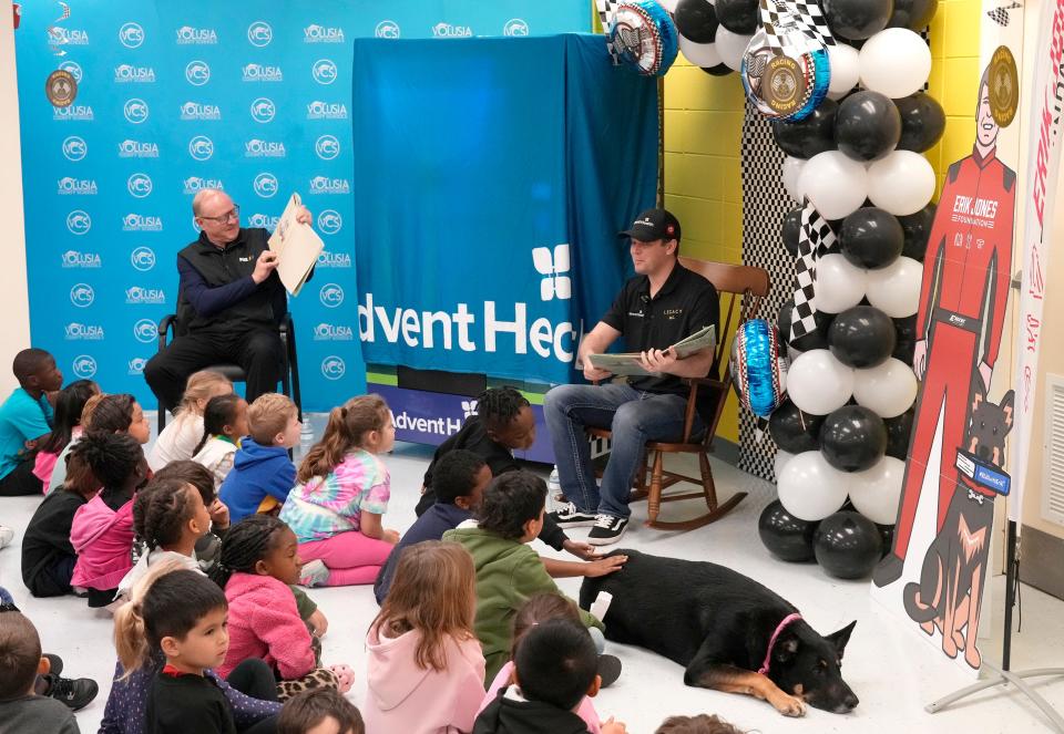 NASCAR driver Erik Jones, pictured with Larry McReynolds and his dog, Oscar, reads to students Blue Lake Elementary School in DeLand, Thursday, Feb. 15, 2024.