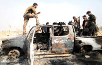 Iraqi special forces soldiers looks at a destroyed Islamic State vehicle in a village near Mosul, Iraq October 25, 2016. REUTERS/Goran Tomasevic