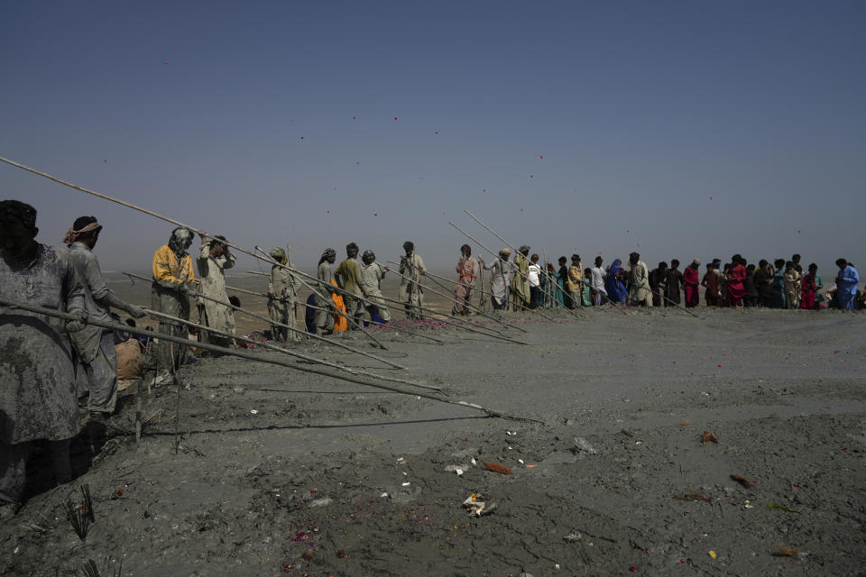 Hindu devotees perform their rituals on a mud volcano to start Hindu pilgrims' religious rituals for an annual festival in an ancient cave temple of Hinglaj Mata in Hinglaj in Lasbela district in the Pakistan's southwestern Baluchistan province, Friday, April 26, 2024. More than 100,000 Hindus are expected to climb mud volcanoes and steep rocks in southwestern Pakistan as part of a three-day pilgrimage to one of the faith's holiest sites. (AP Photo/Junaid Ahmed)