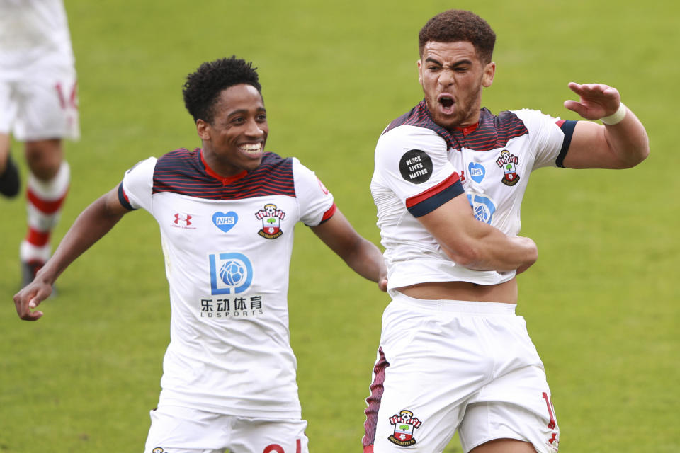 Southampton's Che Adams, right, celebrates with Kyle Walker-Peters after scoring his side's second goal during the English Premier League soccer match between Bournemouth and Southampton at Vitality Stadium in Bournemouth, England, Sunday, July 19, 2020. (Ian Walton/Pool Photo via AP)