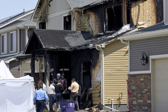 <p>AP Photo/Thomas Peiper</p> Authorities stand outside the burned house where five members of the Diol family were found dead.