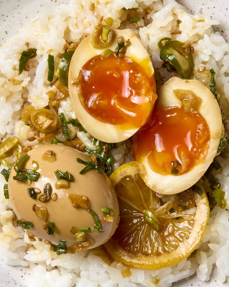 overhead shot of a soy marinated jammy egg, broken open, served over rice.