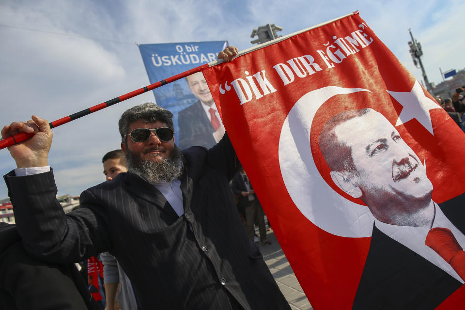 A man gestures before the arrival of Turkey's President Recep Tayyip Erdogan to addresses the supporters of his ruling Justice and Development Party, AKP, at a rally in Istanbul, Tuesday, March 19, 2019, ahead of local elections scheduled for March 31, 2019. (AP Photo/Emrah Gurel)