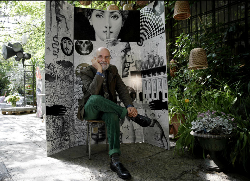 In this picture taken on Wednesday, April 17, 2019, Design artistic director Barnaba Fornasetti poses in front of a paravent folding screen 'Fornasettiana Remix', made with regenerated polystyrene, for the "RO Plastic - Master's Pieces" exhibition, on the sidelines of Milan's Furniture Fair, in Milan, Italy. Scientists and environmental activists have been long raised the alarm on plastic pollution. Now, the high-end design world is getting in on the growing global effort to tackle plastic pollution -- by upcycling discarded objects into desirable one-off design pieces. (AP Photo/Luca Bruno)