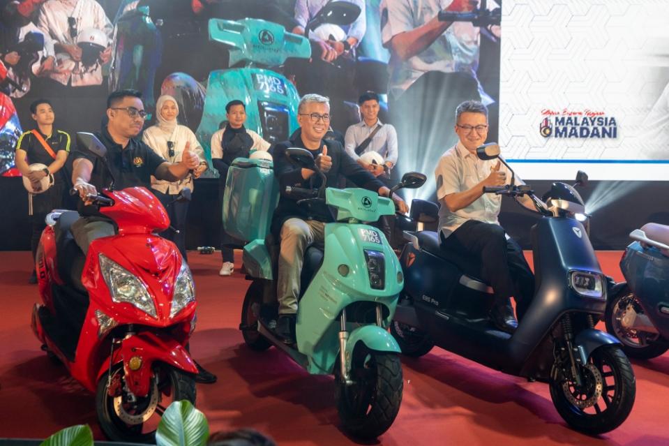 Investment, Trade and Industry Minister Datuk Seri Tengku Zafrul Abdul Aziz poses for a group photo after launching the electric motorcycle rebate scheme during at Bukit Jalil National Stadium. With him is his deputy, Liew Chin Tong. — Picture by Shafwan Zaidon