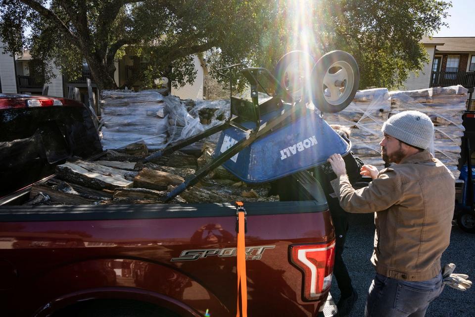 Ronald Cheng of Warner Firewood loads a wheelbarrow into his truck as he prepares to deliver wood to a customer in East Austin on Friday.