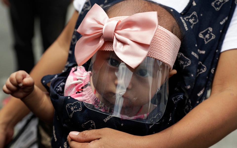 A 6-month-old baby wears a face shield to help protect herself from the coronavirus in Manila, Philippines - Aaron Favila/AP