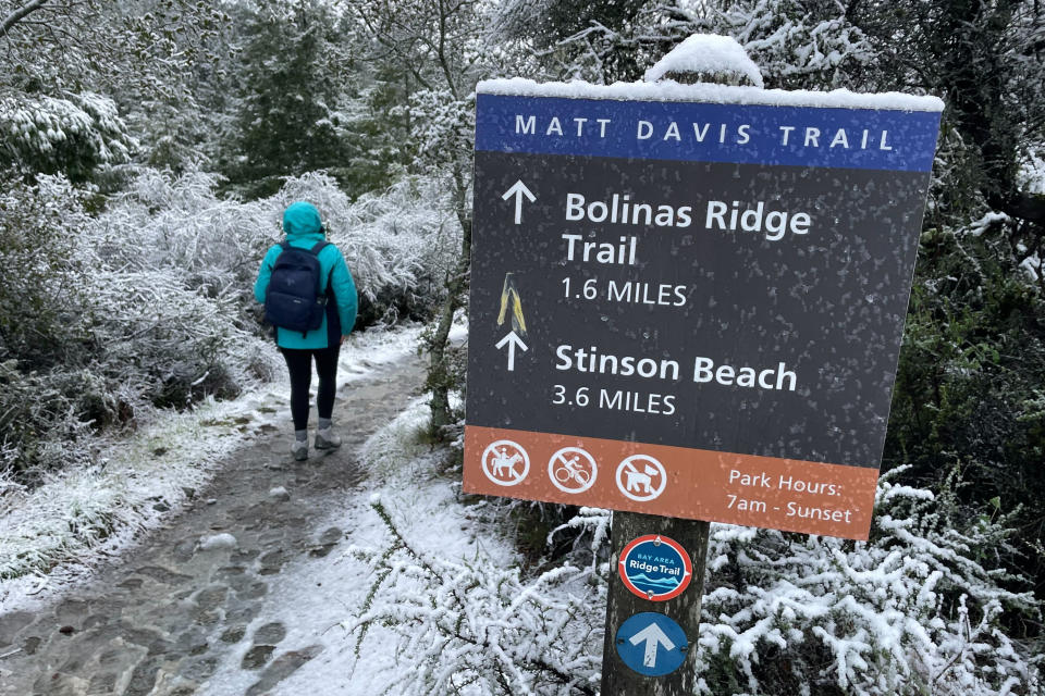 A person walks up a trail at snow-covered Mount Tamalpais State Park in Mill Valley, Calif., Friday Feb. 24, 2023. California and other parts of the West are facing heavy snow and rain from the latest winter storm to pound the United States. The National Weather Service has issued blizzard warnings for the Sierra Nevada and Southern California mountains. (AP Photo/Haven Daley)