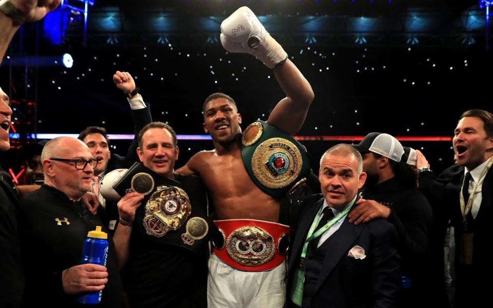 Anthony Joshua celebrates with his team after retaining his IBF heavyweight title and adding the WBA and IBO belts to his collection - Getty Images Europe