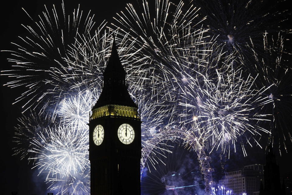 Fireworks illuminate the Elizabeth Tower, part of the Houses of Parliament, and the London Eye in central London during the New Year celebrations, Sunday Jan. 1, 2023. (Aaron Chown/PA via AP)