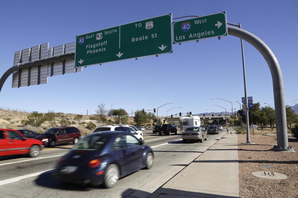 In this Friday, Nov. 8, 2013 photo, motorists roll through a traffic light on southbound U.S. Highway 93, as they approach Interstate 40, in Kingman, Ariz. Supporters of proposals to build an interstate highway connecting Phoenix and Las Vegas say an interstate would create a Los Angeles-Phoenix-Las Vegas “megaregion” and open a trade route from Mexico to Pacific Ocean ports and Canada. (AP Photo/Julie Jacobson)