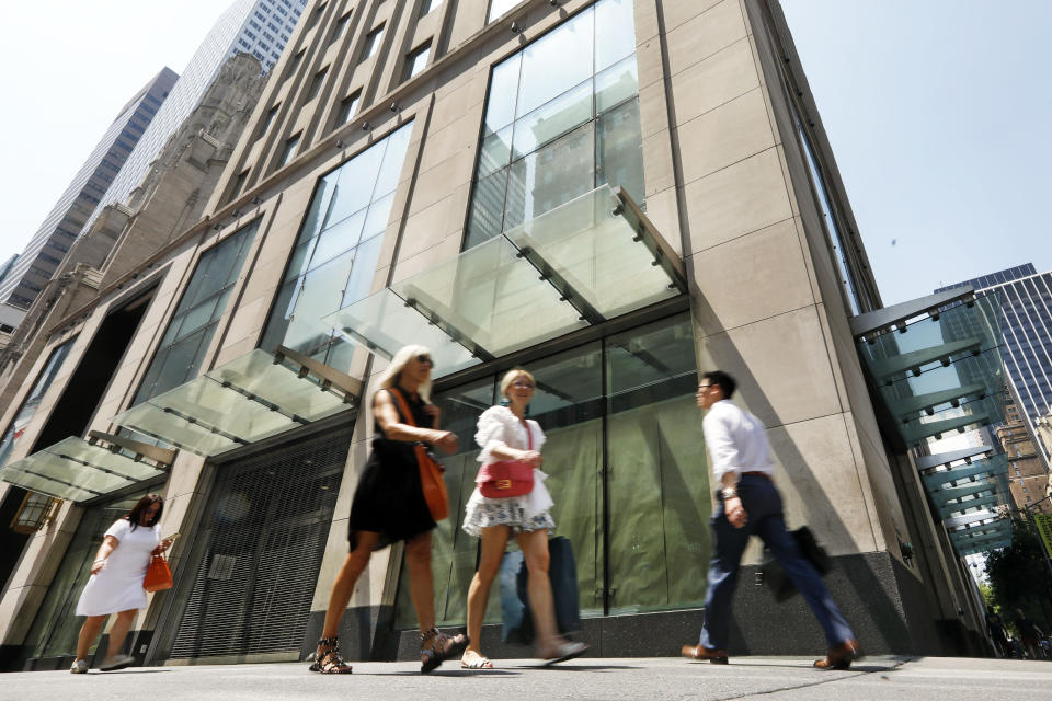 In this July 30, 2019, photo people pass the former Gap store on New York's Fifth Avenue. Over the last year or so, Gap, Tommy Hilfiger, Lord & Taylor and Polo Ralph Lauren have closed their flagship stores on Manhattan's Fifth Avenue. (AP Photo/Richard Drew)