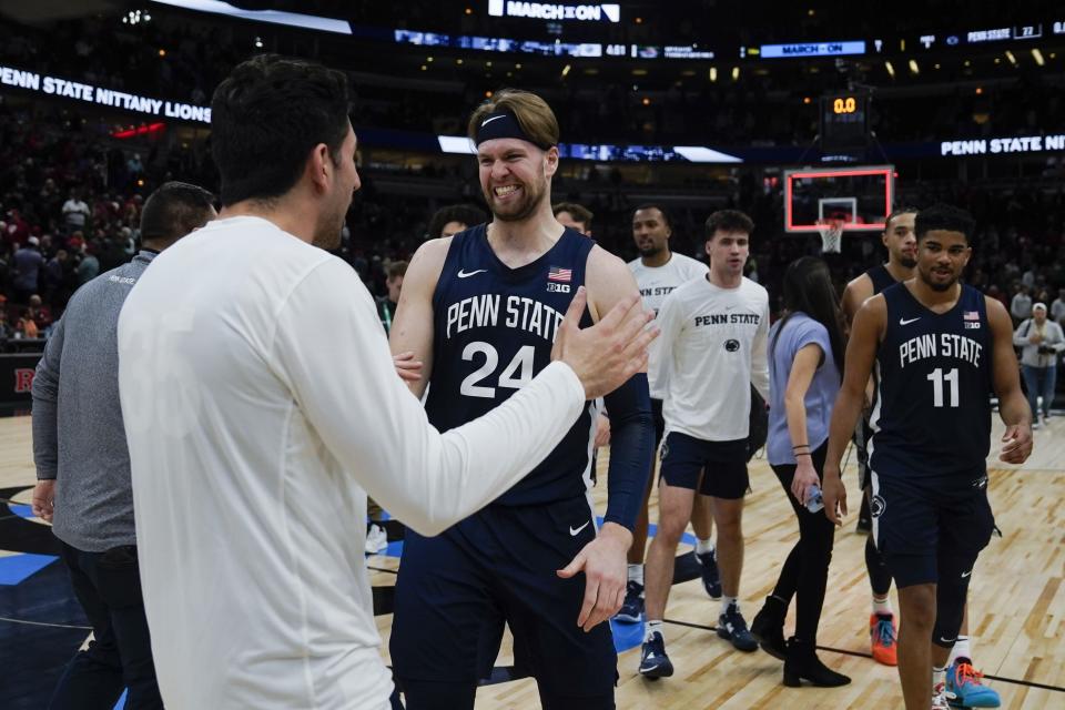 Penn State's Michael Henn (24) celebrates with a teammate following an NCAA semifinal basketball game against Indiana at the Big Ten men's tournament, Saturday, March 11, 2023, in Chicago. Penn State won 77-73. (AP Photo/Erin Hooley)