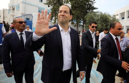 Tunisia's Prime Minister Youssef Chahed, a presidential candidate, waves as he arrives to cast his vote in a polling station during presidential election in Tunis