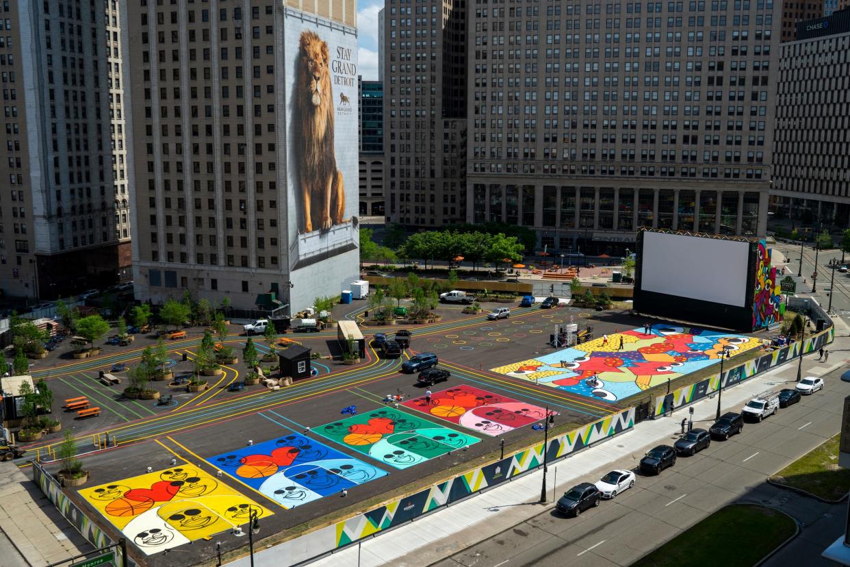 People paint murals for the soon to be opening Monroe Street Midway in downtown Detroit on May 24, 2021. The area will feature a mix of outdoor activities, including food, entertainment and roller skating.