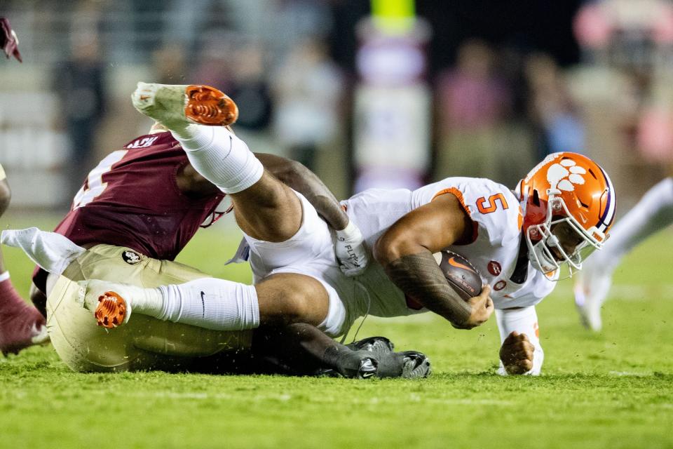 Clemson Tigers quarterback DJ Uiagalelei (5) gets tackled by a defender. The Clemson Tigers defeated the Florida State Seminoles 34-28 at Doak Campbell Stadium Oct. 15, 2022.