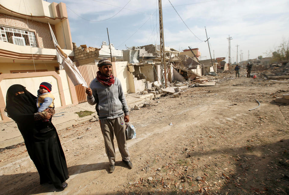 Displaced Iraqis leave their house in Mosul