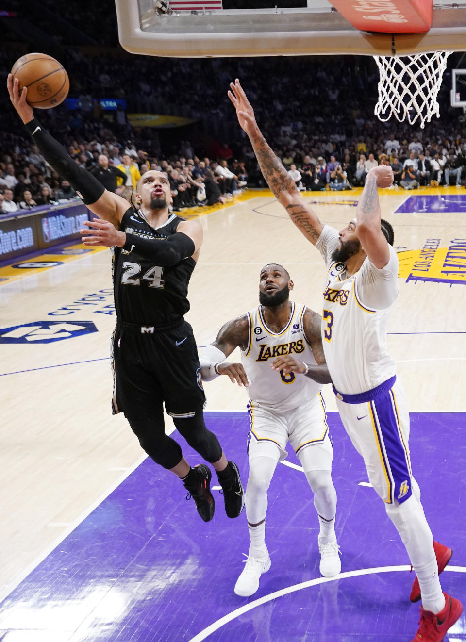 Memphis Grizzlies forward Dillon Brooks, left, shoots as Los Angeles Lakers forward LeBron James, center, and forward Anthony Davis defend during the first half in Game 3 of a first-round NBA basketball playoff series Saturday, April 22, 2023, in Los Angeles. (AP Photo/Mark J. Terrill)