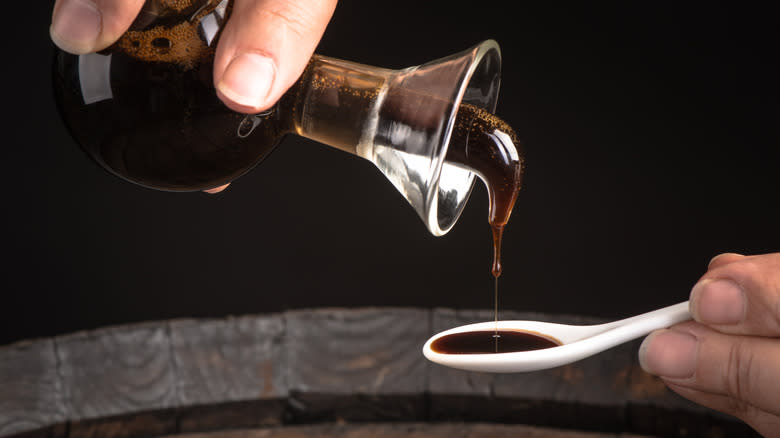 person pouring balsamic vinegar in spoon