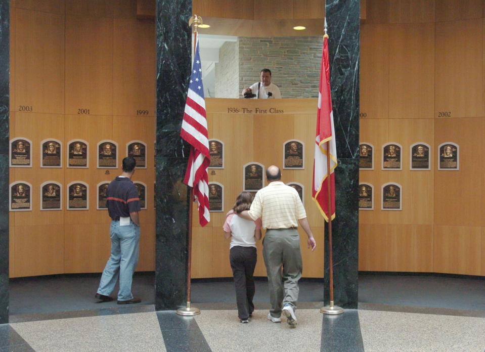 This April 30, 2004 file photo shows museum patrons viewing plaques of recent inductees into the National Baseball Hall of Fame and Museum in Cooperstown, N.Y. There are many destinations of interest to baseball fans around the country outside ballparks from museums and statues to historic homes. (AP Photo/Tim Roske, File)