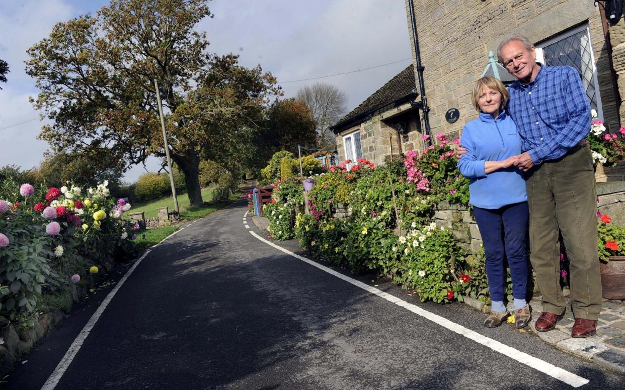 Sally Williams, 69, and her husband Brian, 80, planted the dahlias on Hollin House Lane in Loxley over three decades ago - Sheffield Star / SWNS.com