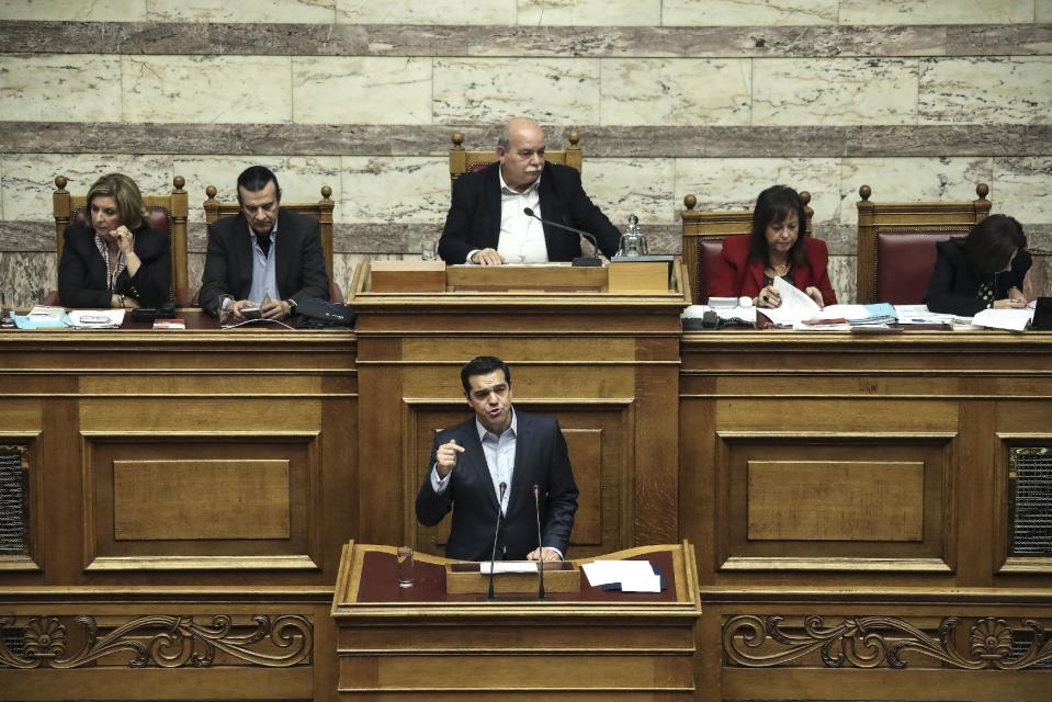 Greece's Prime Minister Alexis Tsipras, front, addresses lawmakers during a parliamentary session in Athens, Saturday, Dec. 10, 2016. Greek parliament votes on 2017 budget, as the country's left-wing government is still negotiating a new series of cost-cutting reforms that are expected to remove protection measures for private sector jobs and distressed mortgage holders. (AP Photo/Yorgos Karahalis)