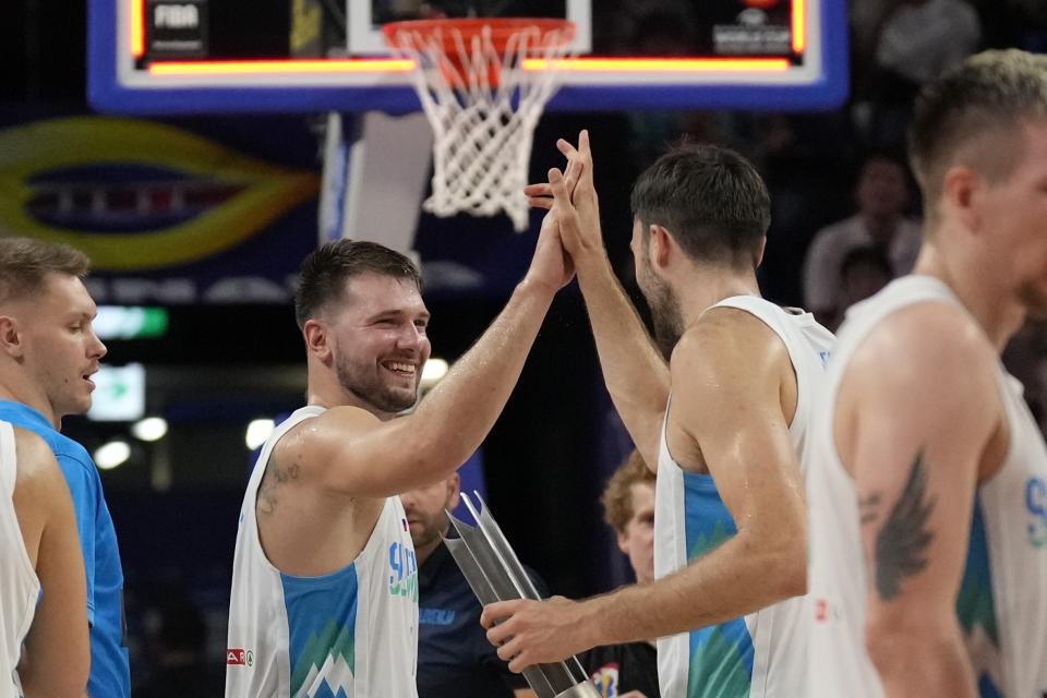 El base de Eslovenia Luka Doncic celebra con su compañero Mike Tobey al vencer a Australia en la segunda ronda de la Copa Mundial de baloncesto el viernes 1 de septiembre del 2023. (AP Foto/Hiro Komae)