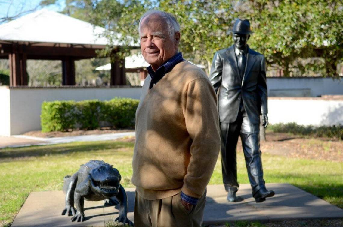 David Pearson, one of the original promoters of Sea Pines, stands for a portrait at Compass Rose Park with the statue of his mentor Charles Fraser walking with the alligator behind him on Feb. 17 on Hilton Head Island.