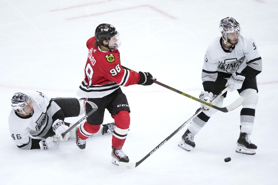 Chicago Blackhawks' Connor Bedard (98) has his shot blocked as Los Angeles Kings' Blake Lizotte (46) and Matt Roy, right, defend during the second period of an NHL hockey game Friday, March 15, 2024, in Chicago. (AP Photo/Charles Rex Arbogast)