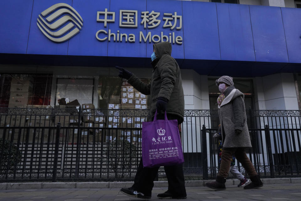 Residents pass by a branch of the China Mobile Ltd. in Beijing on Jan. 8, 2021. Profit at state-owned companies that dominate China's banking, oil and most other industries rose by as much as 25% last year as the country recovered from the coronavirus pandemic, according to the. State-Owned Assets Supervision and Administration Commission which oversees 97 companies directly under the Cabinet including PetroChina Ltd., Asia's biggest oil producer; China Mobile Ltd., the world's biggest phone carrier by number of subscribers, and Industrial and Commercial Bank of China Ltd., the world's biggest bank by assets. (AP Photo/Ng Han Guan)