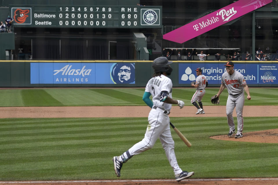 Baltimore Orioles starting pitcher John Means, right, starts to celebrate after Seattle Mariners' J.P. Crawford, foreground, lined out for the final out in a no-hitter by Means in a baseball game Wednesday, May 5, 2021, in Seattle. The Orioles won 6-0. (AP Photo/Ted S. Warren)