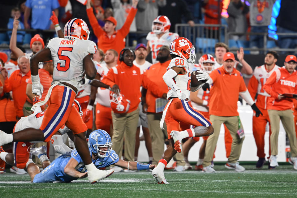 Dec 3, 2022; Charlotte, North Carolina, USA; Clemson Tigers cornerback Nate Wiggins (20) returns an interception 98 yards for a touchdown as North Carolina Tar Heels quarterback Drake Maye (10) defends and Clemson Tigers defensive end K.J. Henry (5) looks on in the third quarter at Bank of America Stadium. Mandatory Credit: Bob Donnan-USA TODAY Sports