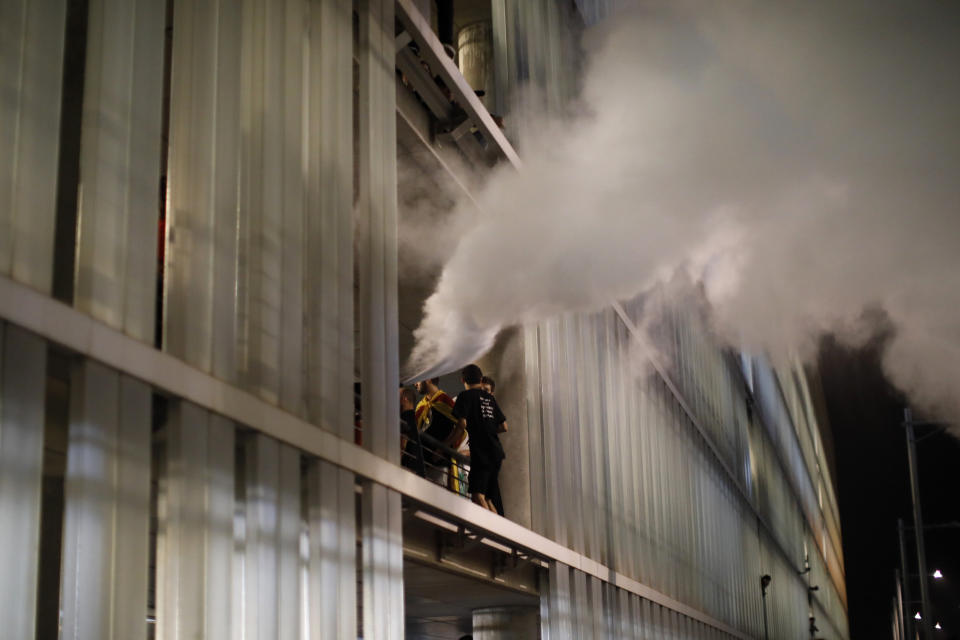 Protestors trigger a fire extinguisher at El Prat airport in Barcelona, Spain, Monday, Oct. 14, 2019. Riot police have charged at protesters outside Barcelona's airport after the Supreme Court sentenced 12 prominent Catalan separatists to lengthy prison terms for their roles in a 2017 push for the wealthy Spanish region's independence. (AP Photo/Emilio Morenatti)