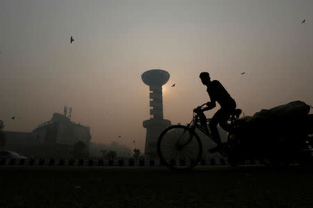 A rickshaw puller passes in front of a shopping mall amidst the heavy smog in New Delhi, India, October 31, 2016. REUTERS/Adnan Abidi