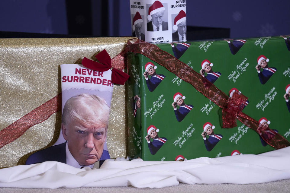 Christmas gifts are seen on the stage during a former President Donald Trump commit to caucus rally, Tuesday, Dec. 19, 2023, in Waterloo, Iowa. (AP Photo/Charlie Neibergall)