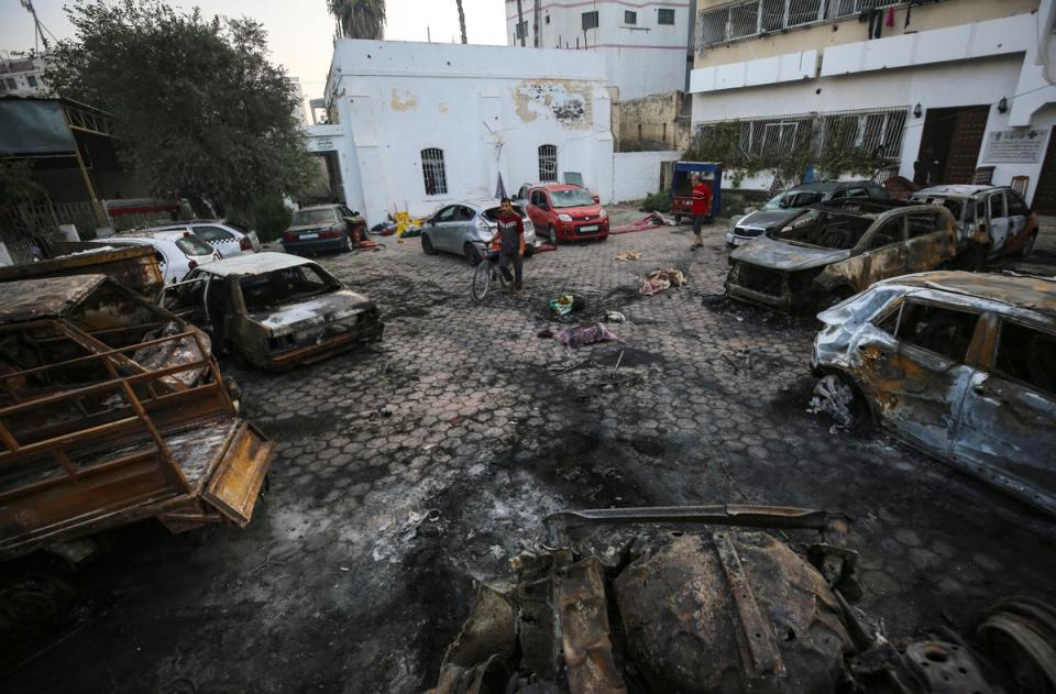 Men look over the site of a deadly explosion at al-Ahli Hospital in Gaza City (AP)