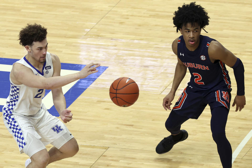 Kentucky's Devin Askew, left, passes away from Auburn's Sharife Cooper during the second half of an NCAA college basketball game in Lexington, Ky., Saturday, Feb. 13, 2021. Kentucky won 82-80. (AP Photo/James Crisp)