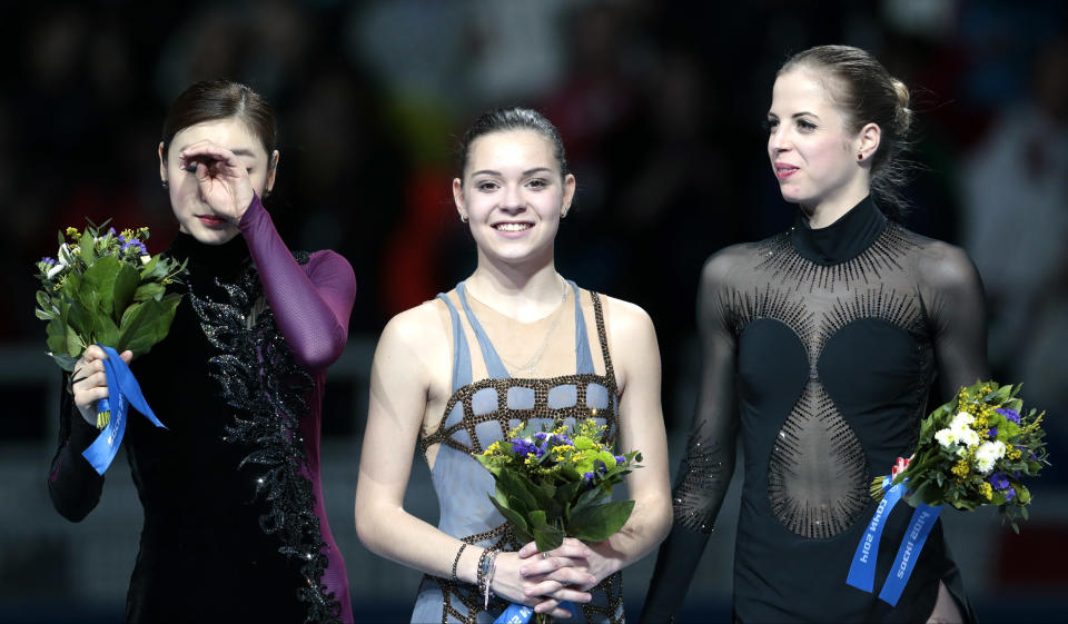 Adelina Sotnikova of Russia, centre, Yuna Kim of South Korea, left, and Carolina Kostner of Italy stand on the podium during the flower ceremony for the women's free skate figure skating final at the Iceberg Skating Palace during the 2014 Winter Olympics, Thursday, Feb. 20, 2014, in Sochi, Russia. Sotnikova placed first, followed by Kim and Kostner. (AP Photo/Ivan Sekretarev)