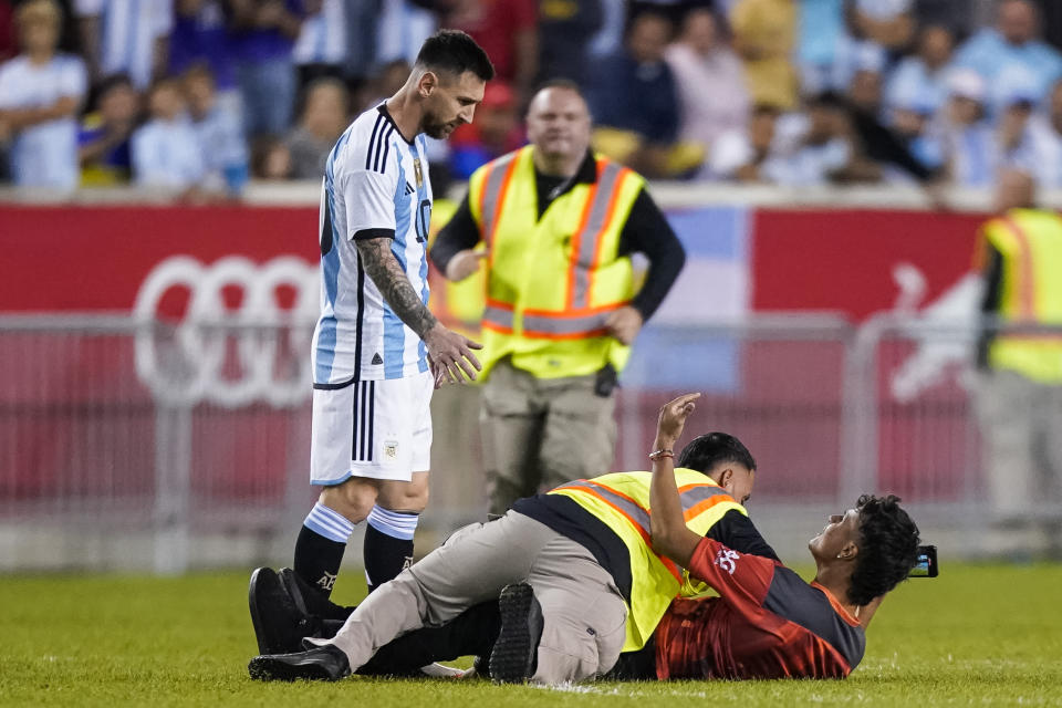 A fan is tackled as he tries to take a picture of Argentina's player Lionel Messi during the second half of an international friendly soccer match against Jamaica on Tuesday, Sept. 27, 2022, in Harrison, N.J. (AP Photo/Eduardo Munoz Alvarez)