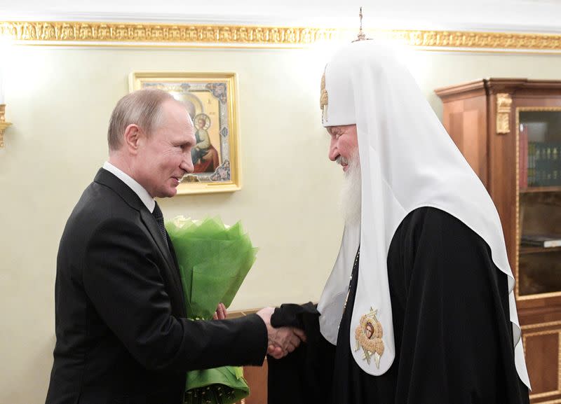 FILE PHOTO: Russian President Vladimir Putin congratulates Patriarch Kirill of Moscow and All Russia on the day of the 11th anniversary of his enthronement in Moscow