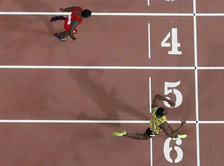 Usain Bolt of Jamaica crosses the finish line ahead of Justin Gatlin of the U.S. as they compete in the men's 200 metres final during the 15th IAAF World Championships at the National Stadium in Beijing, China, August 27, 2015. REUTERS/Pawel Kopczynski