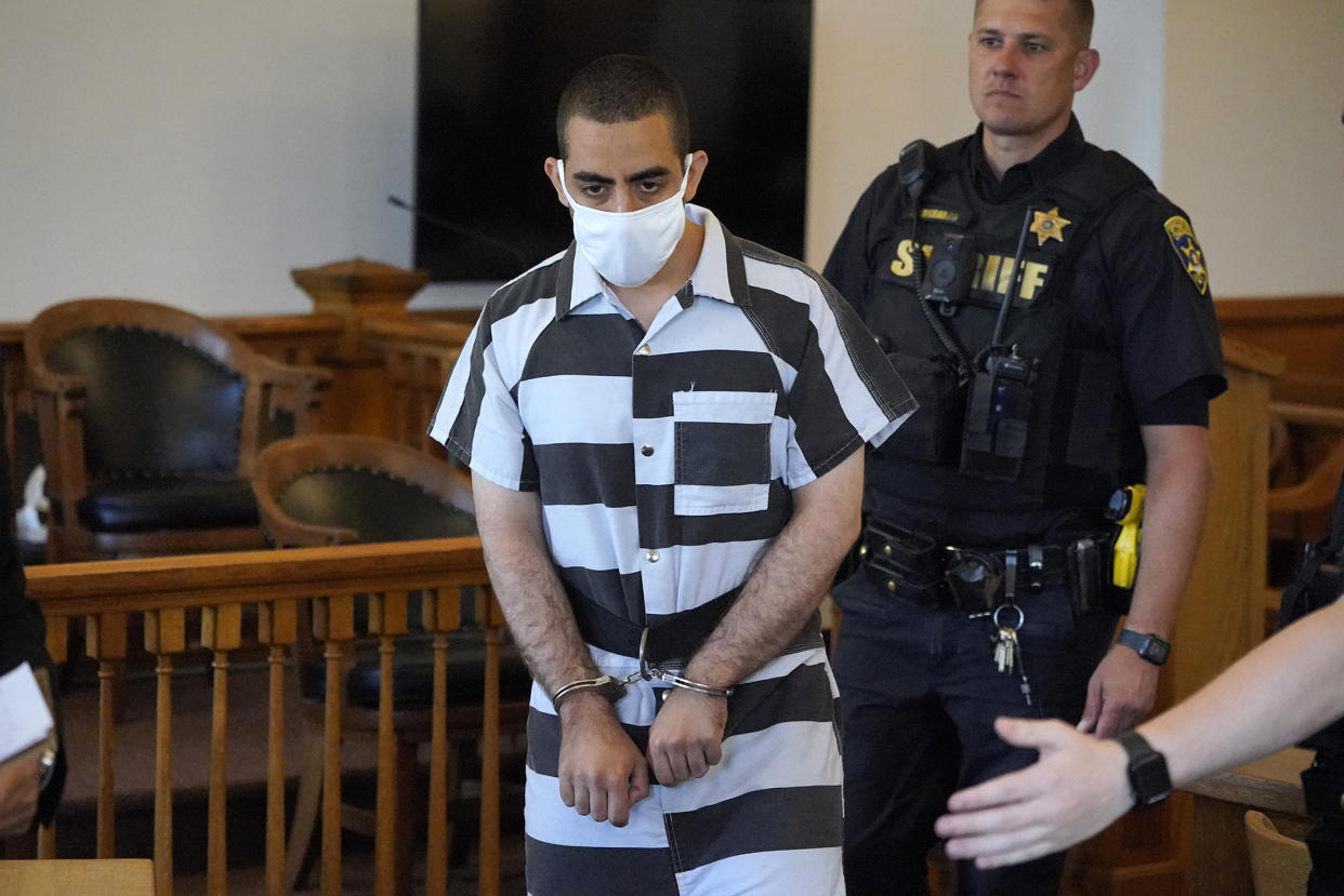 Hadi Matar, 24, center, arrives for an arraignment in the Chautauqua County Courthouse in Mayville, N.Y., Saturday, Aug. 13, 2022. Matar, who is accused of carrying out a stabbing attack against “Satanic Verses” author Salman Rushdie has entered a not-guilty plea in a New York court on charges of attempted murder and assault. An attorney for Matar entered the plea on his behalf during an arraignment hearing. (AP Photo/Gene J. Puskar)