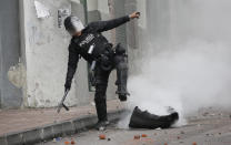 A police officer puts out a fire in a tire placed by people holding a transportation strike to protest the president in Quito, Ecuador, Thursday, Oct. 3, 2019. Ecuador's president has declared a state of emergency to confront street protests and a nationwide transport strike over his decision to end government fuel subsidies and relax labor protections. (AP Photo/Dolores Ochoa)