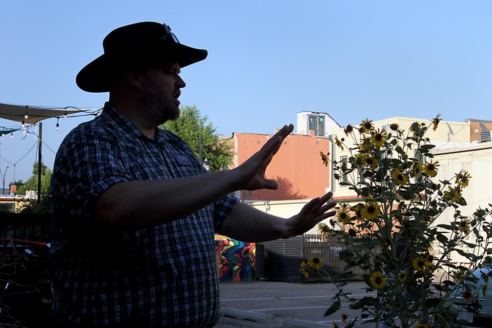 Clint Burkholder, lead tour guide with Fort Collins Tours' ghost tour, goes into detail about the 1888 murder of Eva Howe and lynching of her husband, James, during a recent tour in Old Town on Aug. 27, 2023.