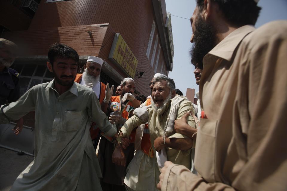 A man (C) cries over the death of his relative, who was killed in a bomb blast, at a hospital in Peshawar September 29, 2013. Twin blasts in the northwestern Pakistan city of Peshawar killed 33 people and wounded 70 on Sunday, a week after two bombings at a church in the frontier city killed scores, police and hospital authorities said. REUTERS/ Fayaz Aziz (PAKISTAN - Tags: POLITICS CIVIL UNREST CRIME LAW)